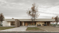 Modern house with a driveway and cars on a cloudy day
