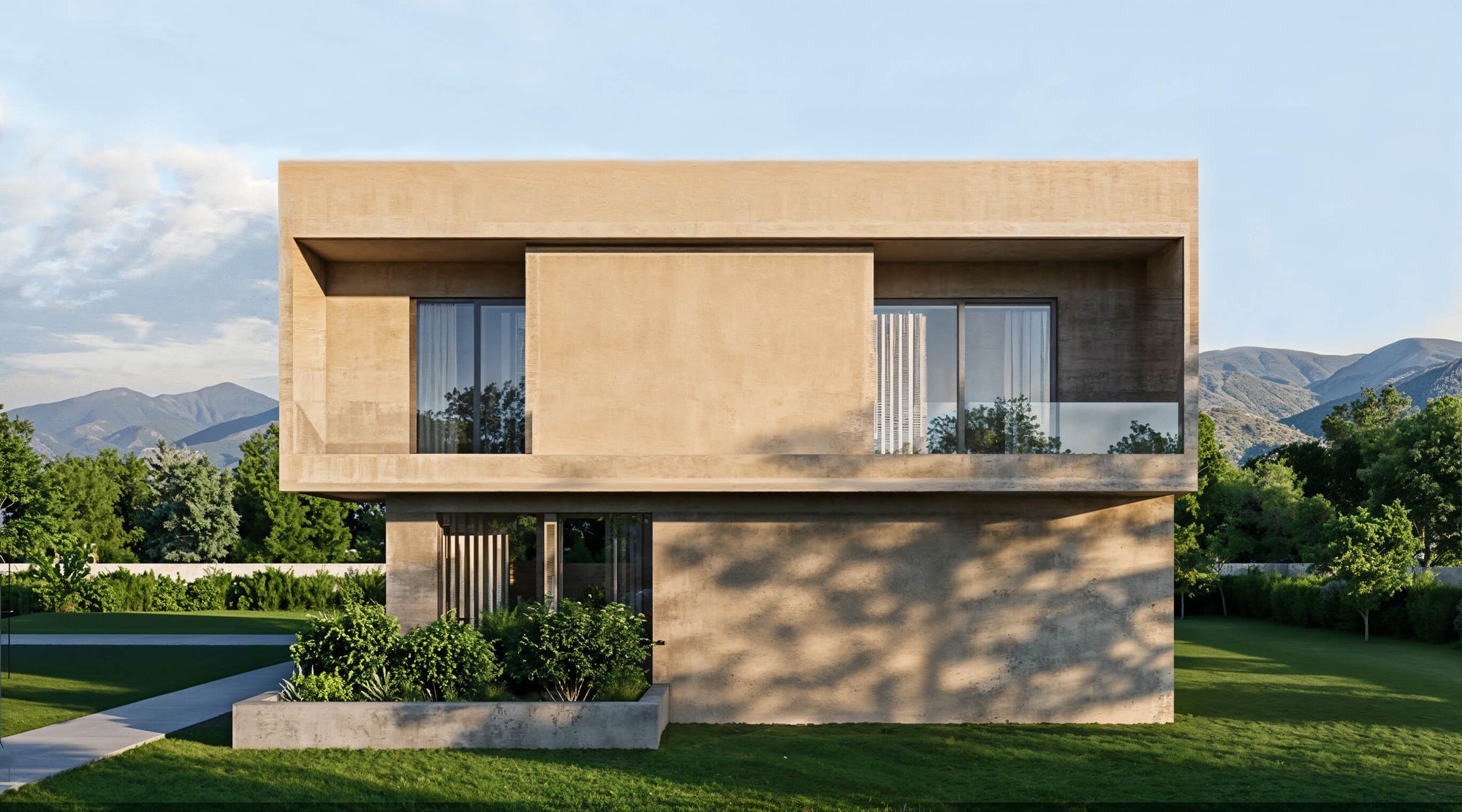 Modern house with concrete exterior in a scenic location with mountains and trees.